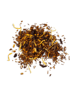 A pile of dry, caffeine-free organic rooibos tea leaves mixed with pieces of tropical fruit and blossoms.